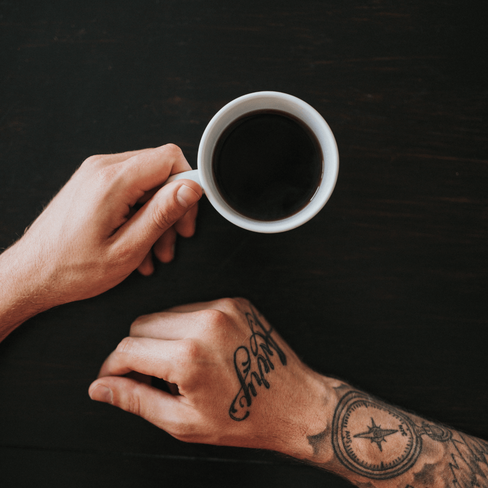 man with tattoos and black coffee