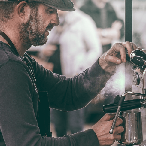 man making a coffee on an espresso machine